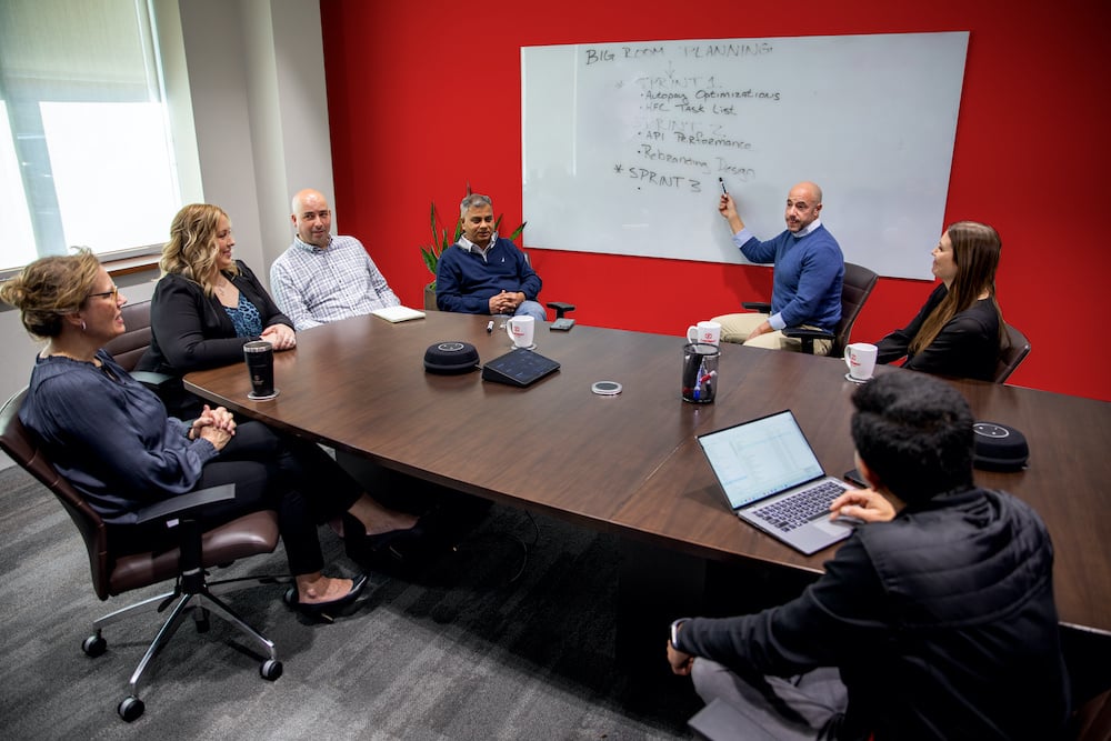 A group of people sitting around a conference table having a meeting.